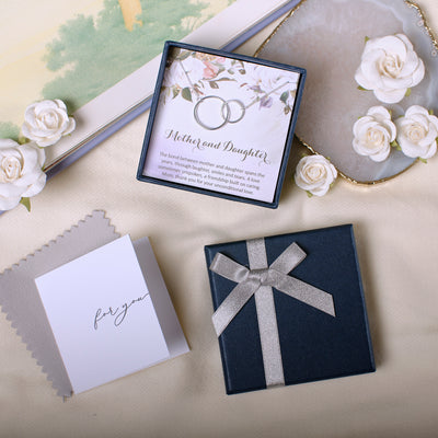 a table topped with cards and a box of wedding rings